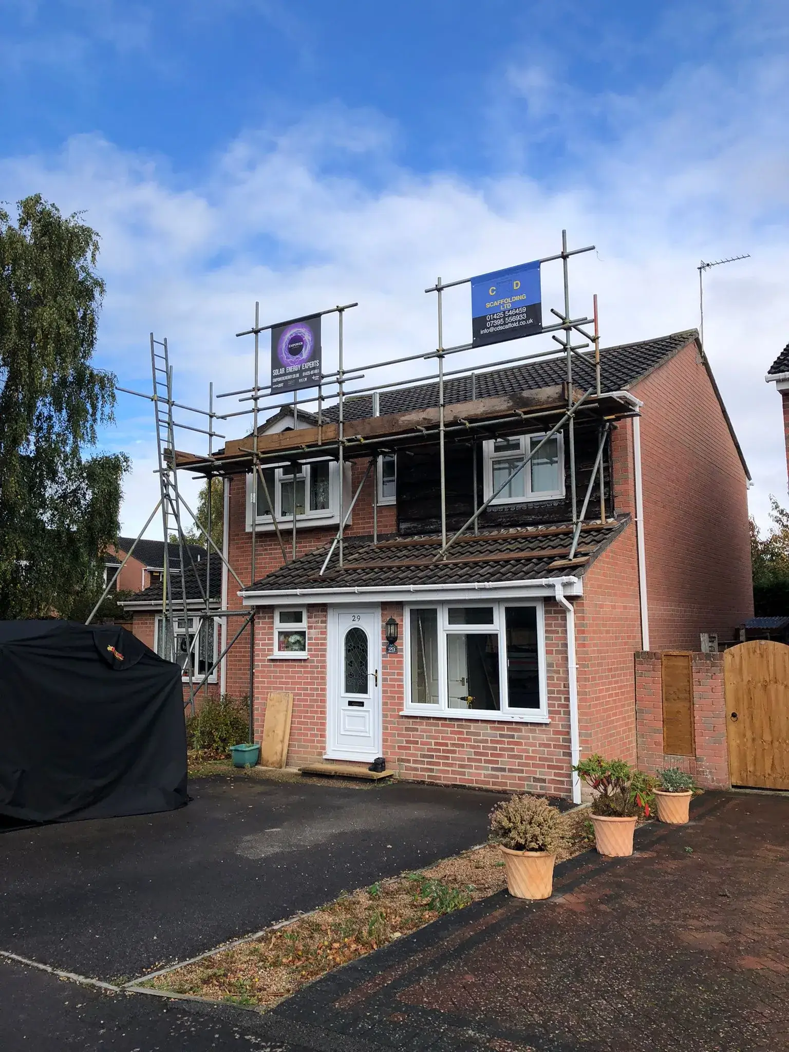 A house under construction with scaffolding on the roof.